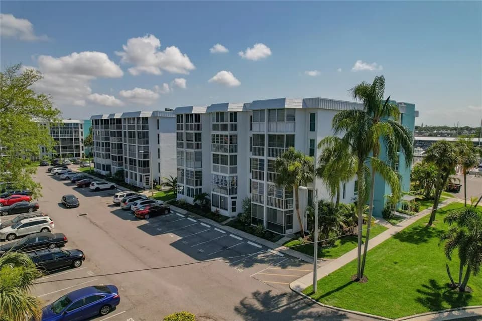 Main building with palm-lined parking